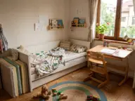 Pat extensibil cu salteaua în segmente, birou reglabil în înălțime și scaun cu suport de picioare, în camera copilului